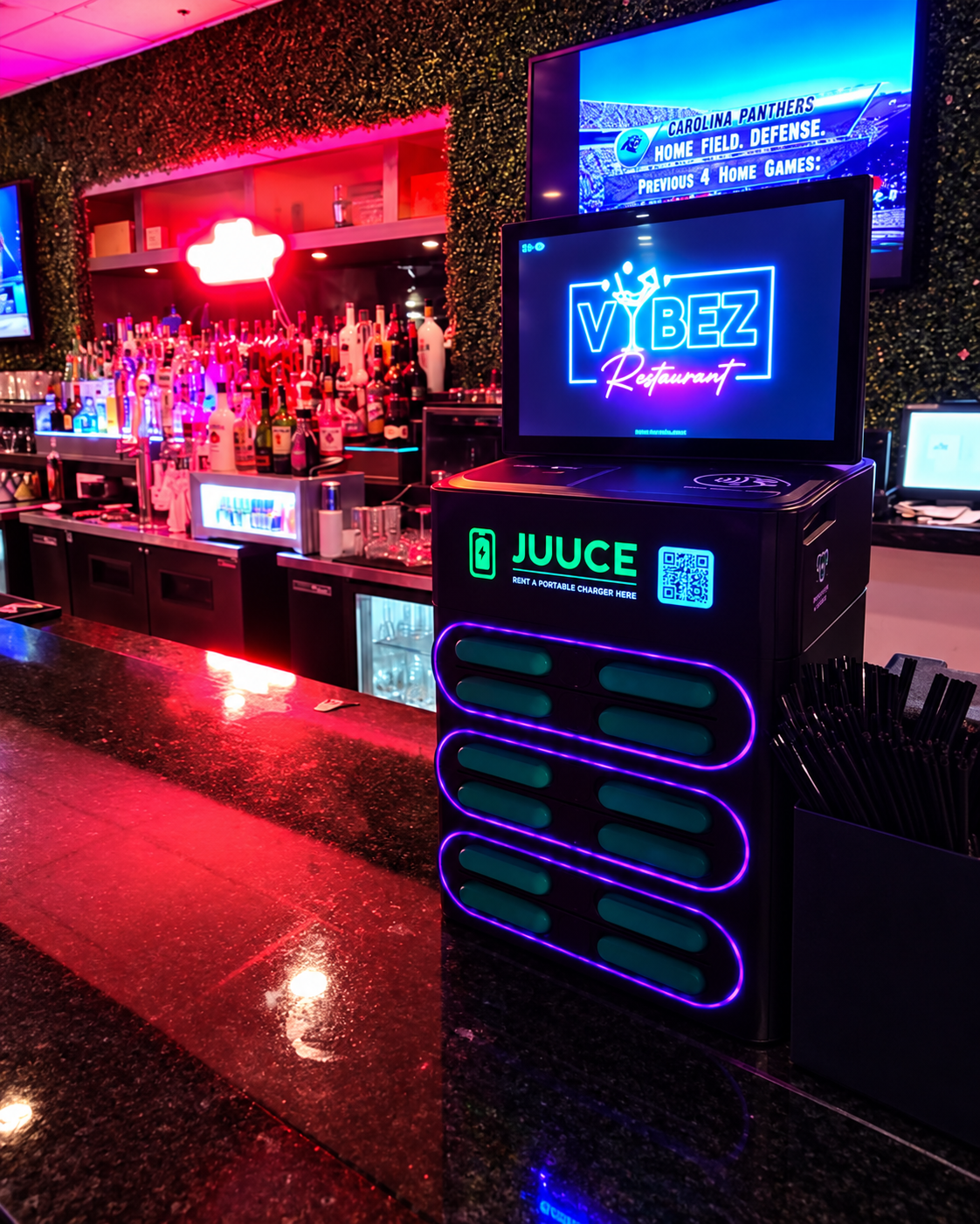 Illuminated JUUCE portable charging station installed at a nightlife venue bar